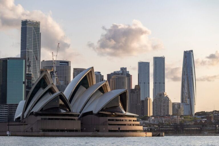 Sydney Opera House with sail-shaped roofs at sunset against a blue sky